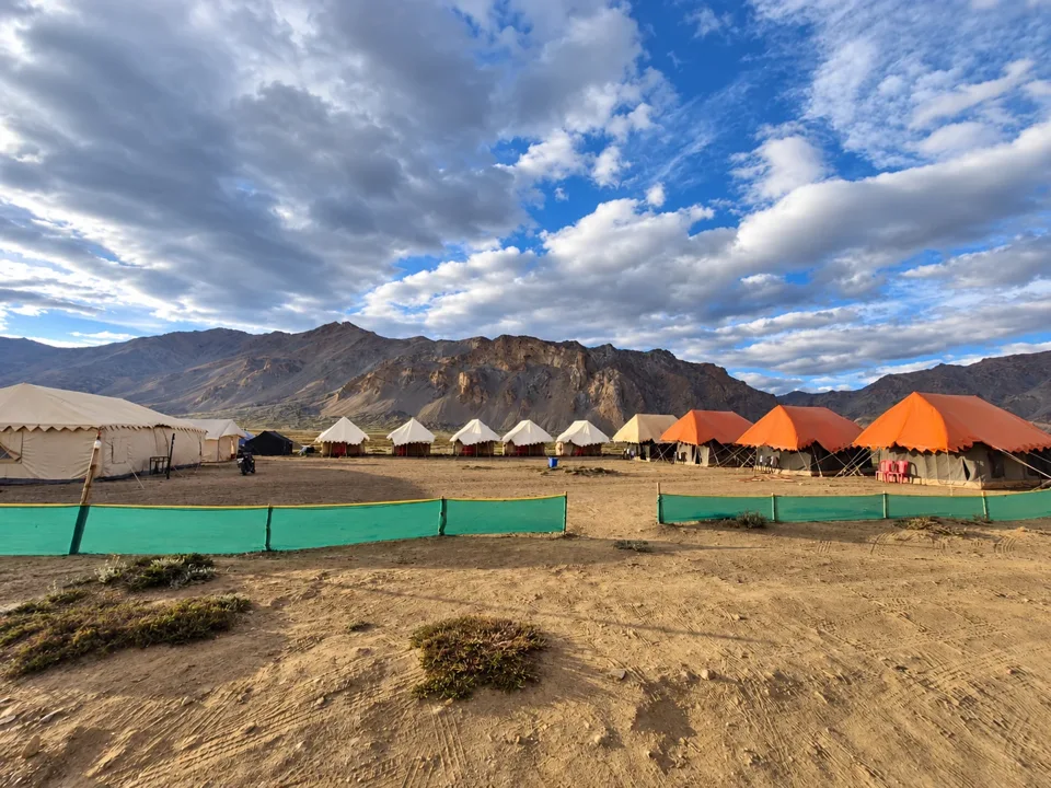 Tents beneath a dramatic mountain sky