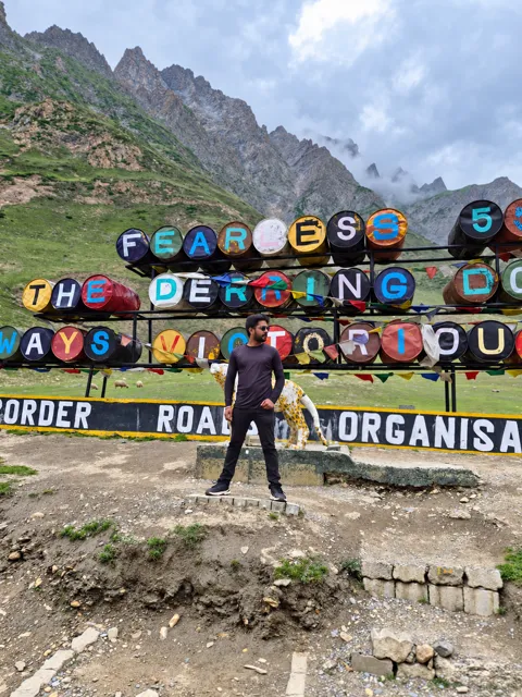 Traveller beside a colourful roadside display in the mountains